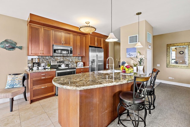 50 Nohea Kai Dr Unit 2-702, Lahaina, HI 96761 - kitchen featuring stainless steel appliances, brown cabinetry, a breakfast bar, light stone countertops, and backsplash