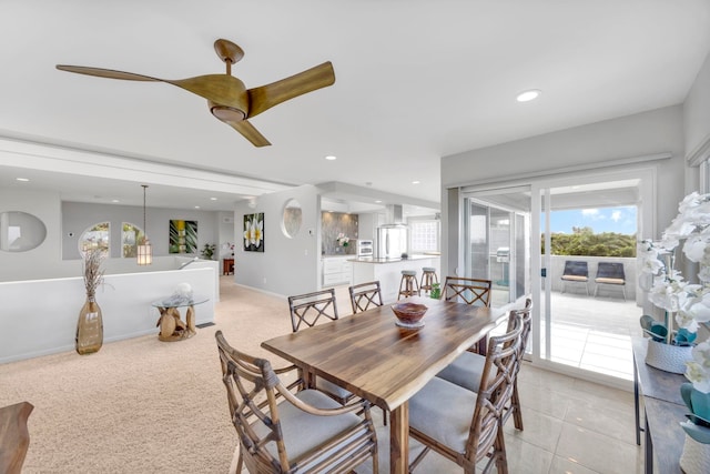 carpeted dining space with ceiling fan