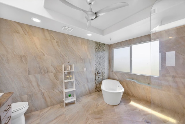 full bathroom featuring ceiling fan, a raised ceiling, tile walls, and plus walk in shower