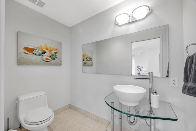 bathroom with sink, toilet, and tile patterned flooring