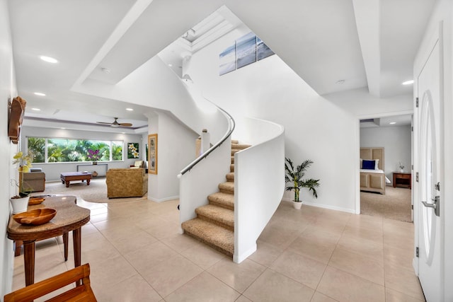 stairway featuring ceiling fan and tile patterned floors