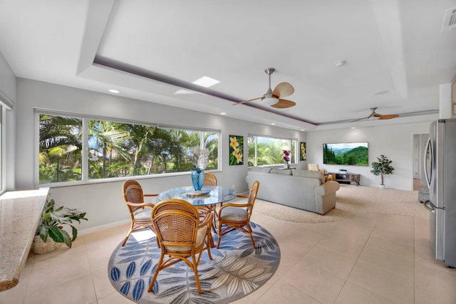 sunroom with plenty of natural light, ceiling fan, and a raised ceiling