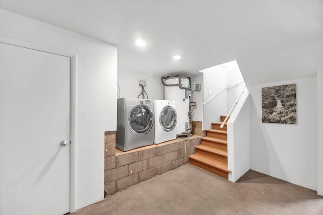 clothes washing area with independent washer and dryer and gas water heater