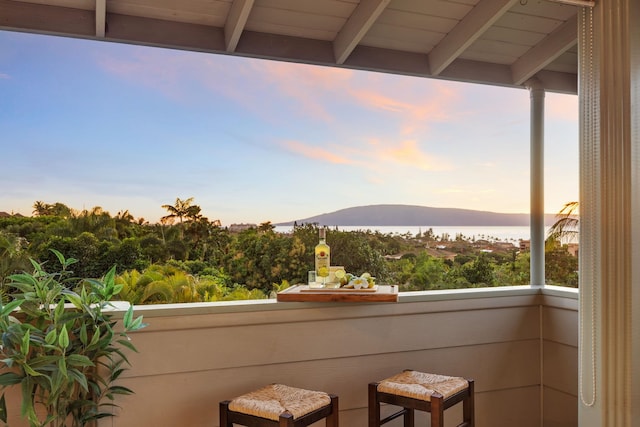 balcony at dusk featuring a mountain view