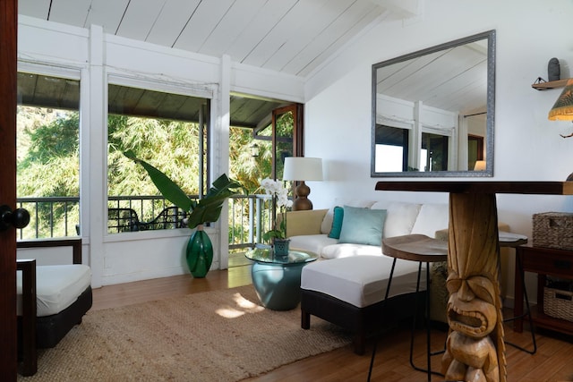 sunroom / solarium featuring lofted ceiling with beams and a healthy amount of sunlight