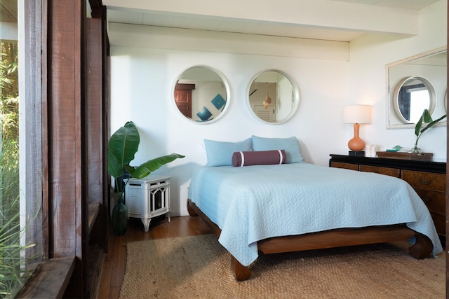 bedroom featuring beamed ceiling and dark wood-type flooring