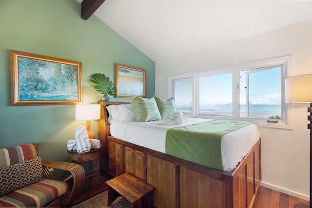 bedroom with lofted ceiling with beams and hardwood / wood-style flooring