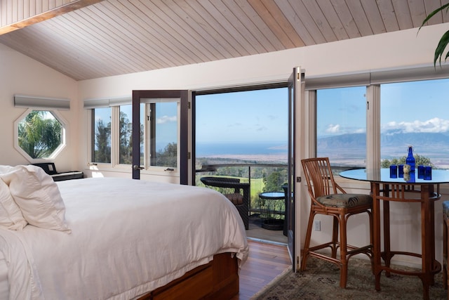 bedroom featuring wooden ceiling, lofted ceiling, multiple windows, a water view, and hardwood / wood-style flooring