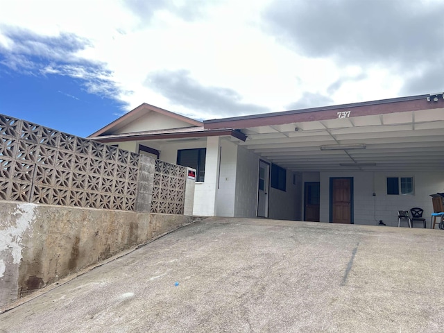 737 Kolani Pl, Wailuku, HI 96793 - exterior space with concrete block siding, an attached carport, and concrete driveway