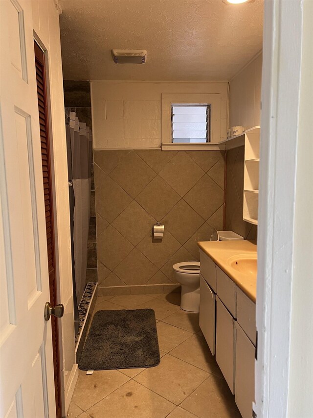 737 Kolani Pl, Wailuku, HI 96793 - full bathroom featuring a textured ceiling, toilet, tile patterned flooring, and a shower stall