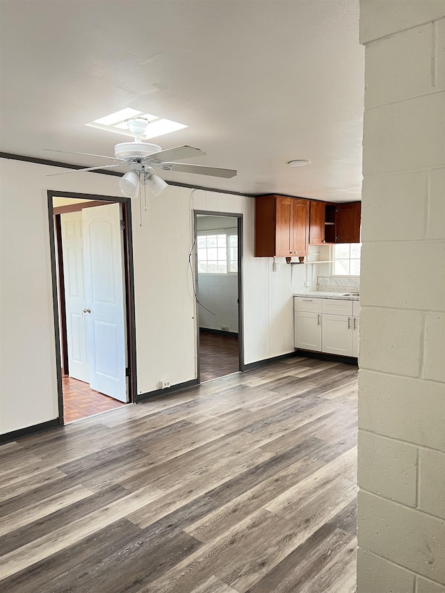 737 Kolani Pl, Wailuku, HI 96793 - unfurnished living room with plenty of natural light, a skylight, ceiling fan, and wood finished floors