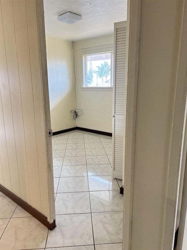 737 Kolani Pl, Wailuku, HI 96793 - corridor featuring a textured ceiling, wooden walls, and light tile patterned floors