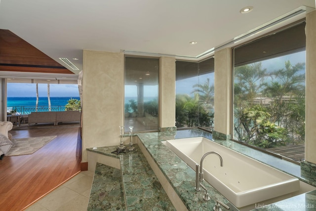 bathroom featuring hardwood / wood-style floors, a water view, and a wealth of natural light