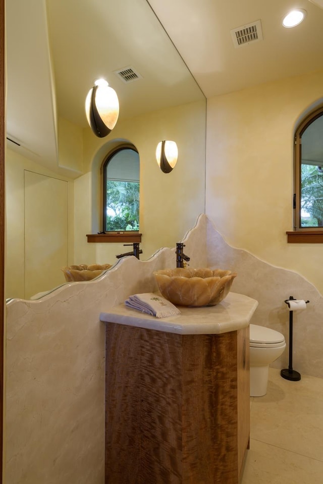 bathroom featuring tile patterned flooring, vanity, and toilet