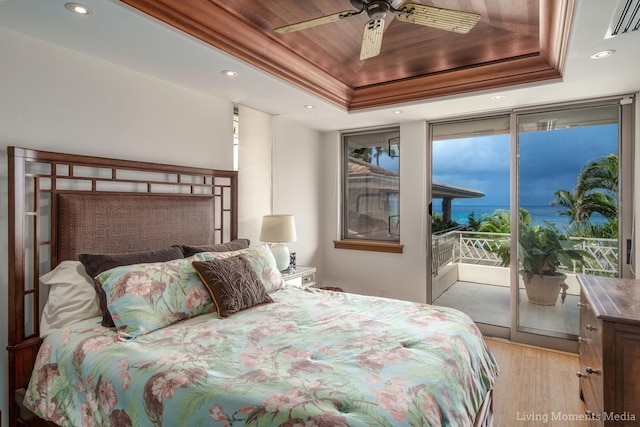 bedroom featuring access to outside, a raised ceiling, ceiling fan, and light hardwood / wood-style flooring