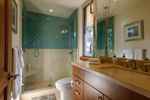 bathroom with tile patterned floors, vanity, toilet, and walk in shower