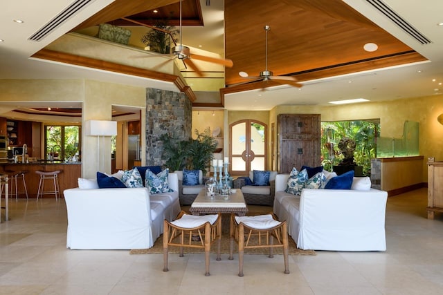 living room with a raised ceiling and ceiling fan