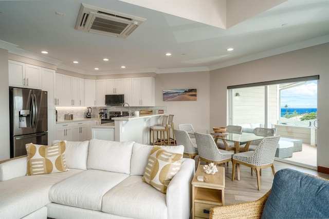 living room featuring light hardwood / wood-style flooring and crown molding