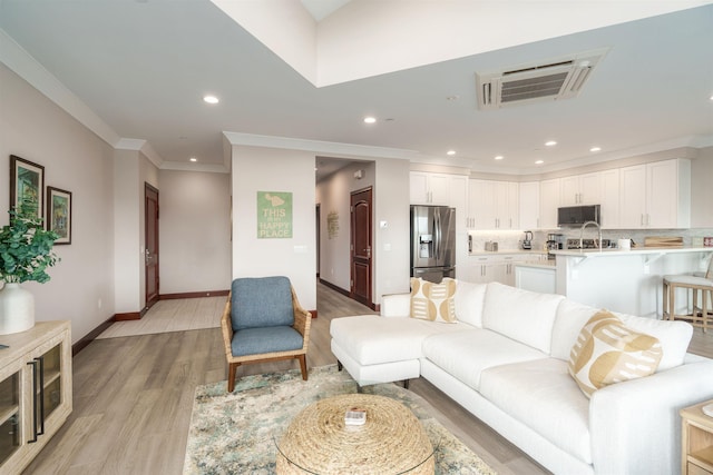 living room featuring light wood-type flooring and ornamental molding