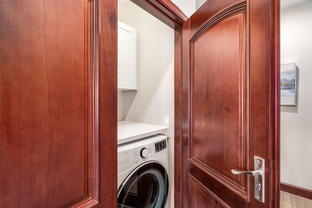 washroom with washer / dryer and cabinets