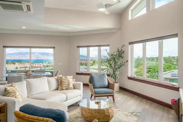 living room featuring ceiling fan, light hardwood / wood-style floors, and a mountain view