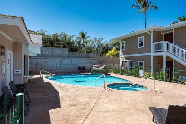 view of pool with a patio area and an in ground hot tub