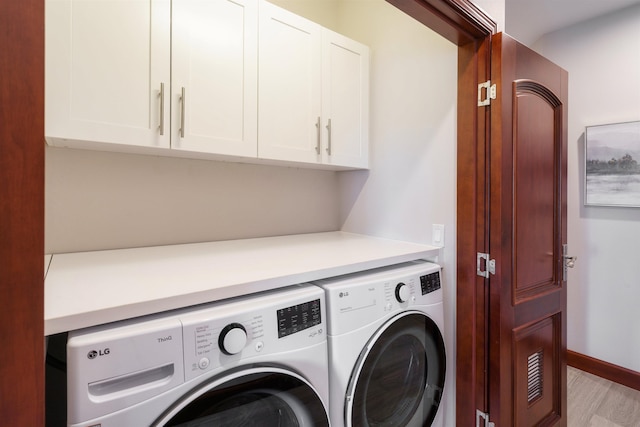 laundry area featuring light hardwood / wood-style floors, cabinets, and independent washer and dryer