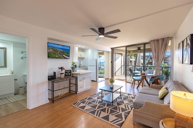 3823 Lower Honoapiilani Rd Unit 302, Lahaina, HI 96761 - living room featuring light wood-type flooring, ceiling fan, and a wall of windows