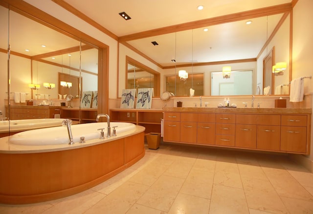 bathroom featuring a tub, vanity with extensive cabinet space, ornamental molding, and tile floors