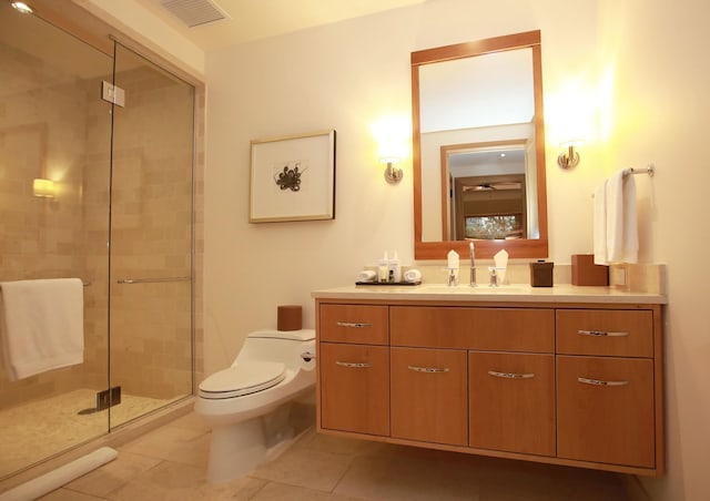 bathroom with tile flooring, a shower with shower door, toilet, and vanity