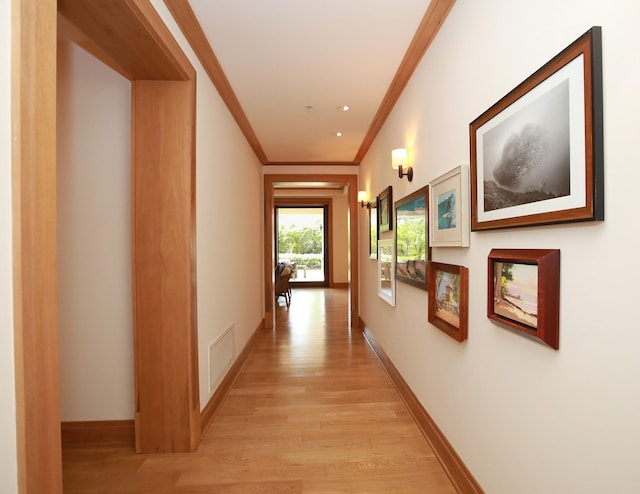 hall with crown molding and light wood-type flooring