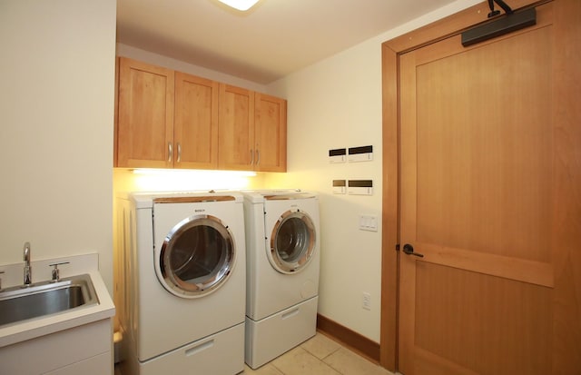 clothes washing area featuring cabinets, sink, independent washer and dryer, and light tile floors