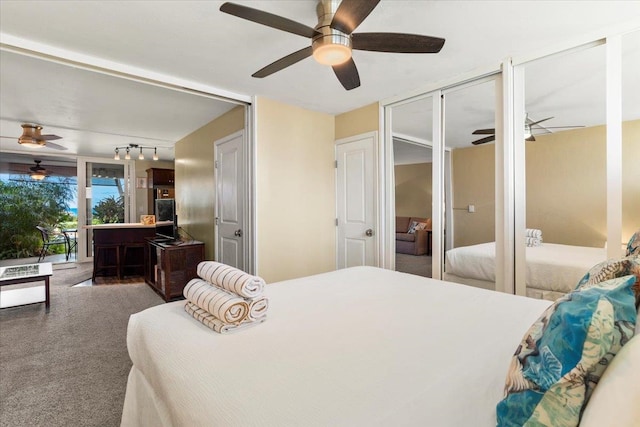 bedroom with carpet floors, track lighting, and ceiling fan