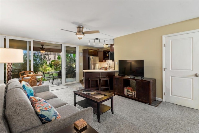 carpeted living room featuring ceiling fan, sink, and track lighting