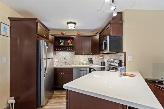 kitchen featuring light wood-type flooring, dark brown cabinetry, sink, appliances with stainless steel finishes, and backsplash