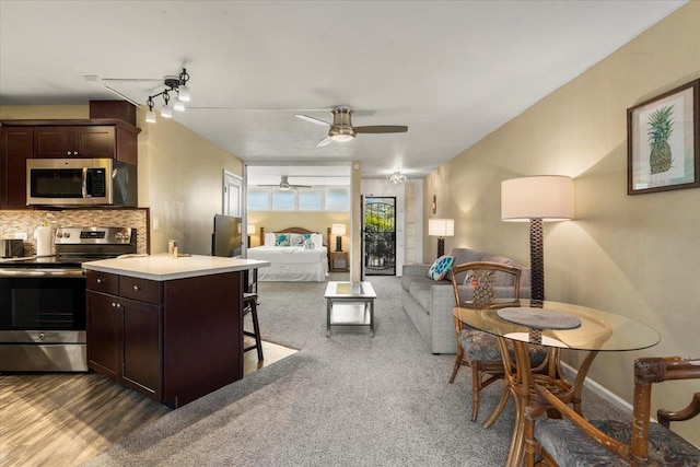 kitchen featuring dark brown cabinets, decorative backsplash, a center island, and stainless steel appliances