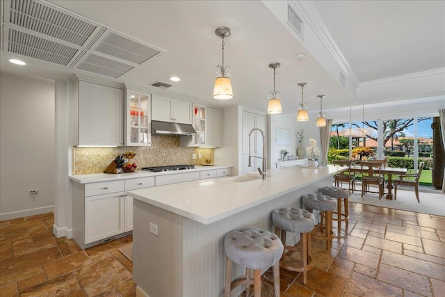 357 Umeke St Unit 144, Kihei, HI 96753 - kitchen featuring stone tile floors, ornamental molding, recessed lighting, gas cooktop, and under cabinet range hood