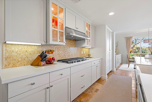 357 Umeke St Unit 144, Kihei, HI 96753 - kitchen with backsplash, stainless steel gas cooktop, under cabinet range hood, and stone tile floors