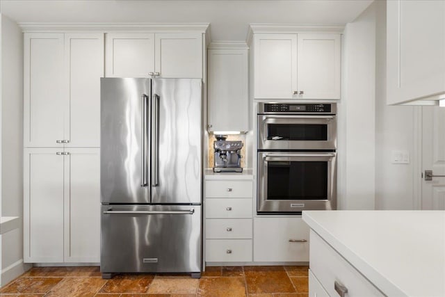 357 Umeke St Unit 144, Kihei, HI 96753 - kitchen featuring light countertops, stone finish flooring, white cabinets, and appliances with stainless steel finishes