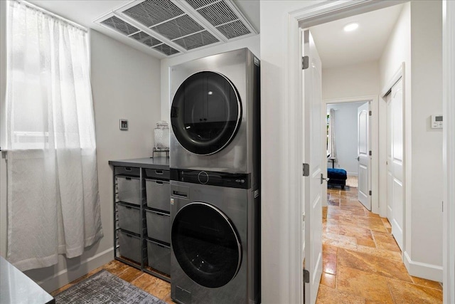 357 Umeke St Unit 144, Kihei, HI 96753 - clothes washing area with baseboards, stacked washer and clothes dryer, stone tile floors, and visible vents