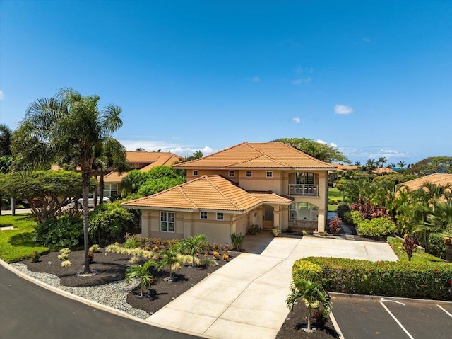 357 Umeke St Unit 144, Kihei, HI 96753 - mediterranean / spanish-style house with stucco siding, an attached garage, a tile roof, and a balcony