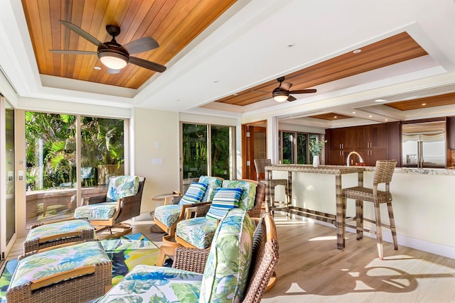 sunroom / solarium featuring sink, a tray ceiling, ceiling fan, and wood ceiling