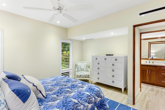 bedroom featuring ceiling fan, sink, connected bathroom, and light hardwood / wood-style flooring