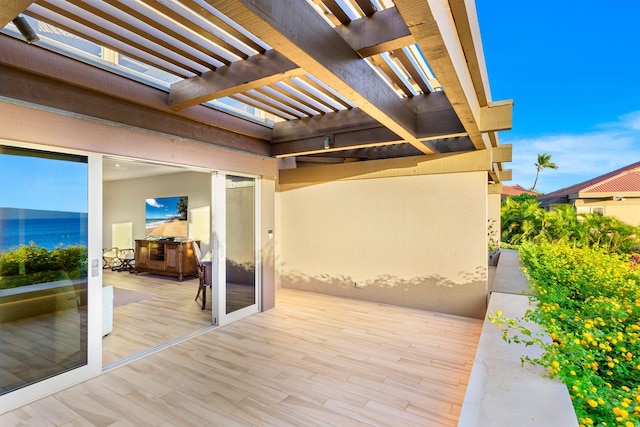 view of patio / terrace with a pergola and a water view