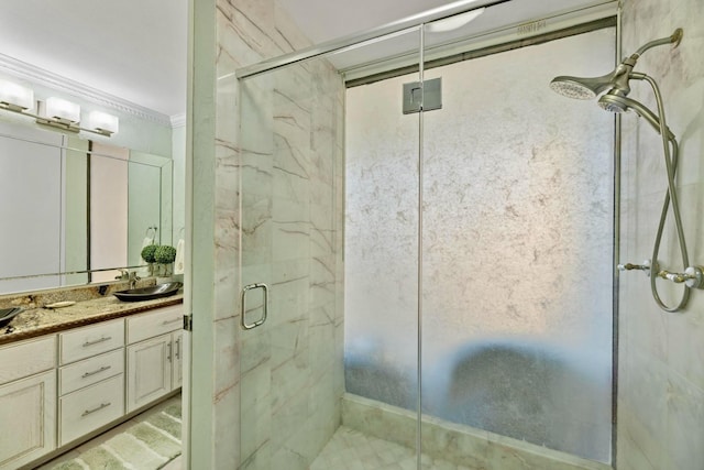 bathroom featuring a marble finish shower, a sink, and double vanity