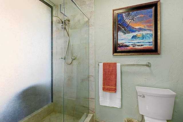 bathroom with a shower stall and toilet
