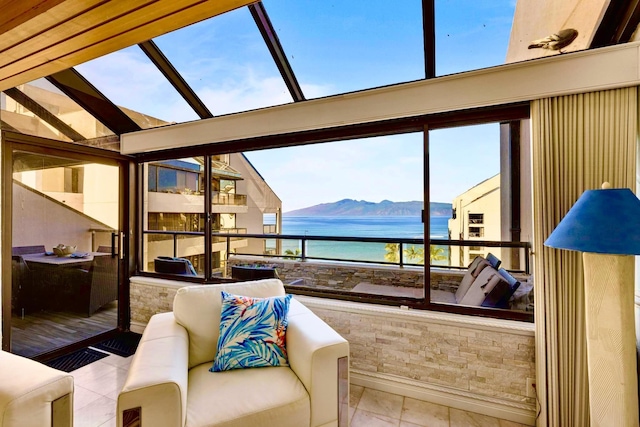 interior space with a water and mountain view and an outdoor living space