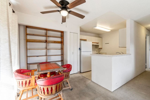 140 Uwapo Rd Unit 18-203, Kihei, HI 96753 - kitchen featuring freestanding refrigerator, light colored carpet, a ceiling fan, a peninsula, and under cabinet range hood