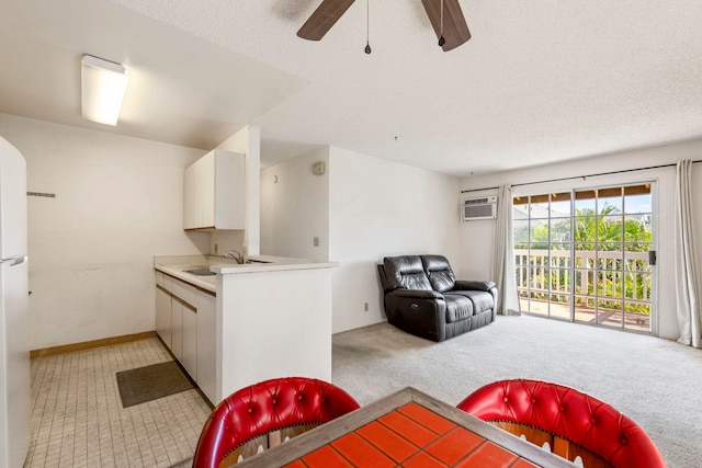 140 Uwapo Rd Unit 18-203, Kihei, HI 96753 - kitchen featuring light colored carpet, a ceiling fan, white cabinetry, open floor plan, and light countertops