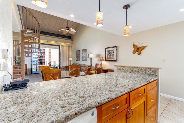 kitchen featuring light stone counters, lofted ceiling, hanging light fixtures, and ceiling fan